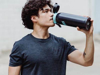 A person drinking water from a reusable bottle after a workout.