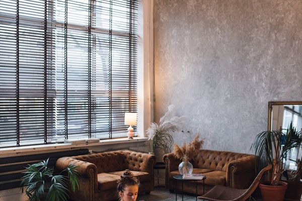 A person stretching on a mat in a bright, minimalist room.