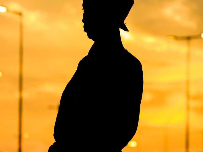 Silhouette of a person in a dynamic pose against a sunset.